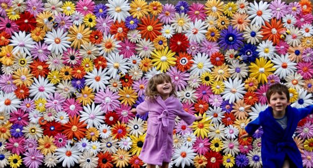 â€œDaisy Chainsâ€ - Little Rundle Street, Adelaide. The big arse wall of flowers I made as part of the Adelaide Fringe Festival Street Art project drawing attention to the fact that bees need flowers. It accompanied a seed drop of 200 packets.  This piece measured 3 metres x 1.8 metres and was made from woven and crocheted plastic bags.  I made the kids too :)